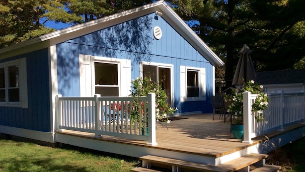 A blue house with a wooden deck, white railings, and a small porch. - ☀️Summer dates available!  (Mears)