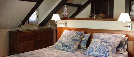 A bedroom with a bed, two nightstands, a dresser, and a mirror.