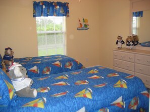 Een slaapkamer met twee bedden, een dressoir en een raam met zonwering.