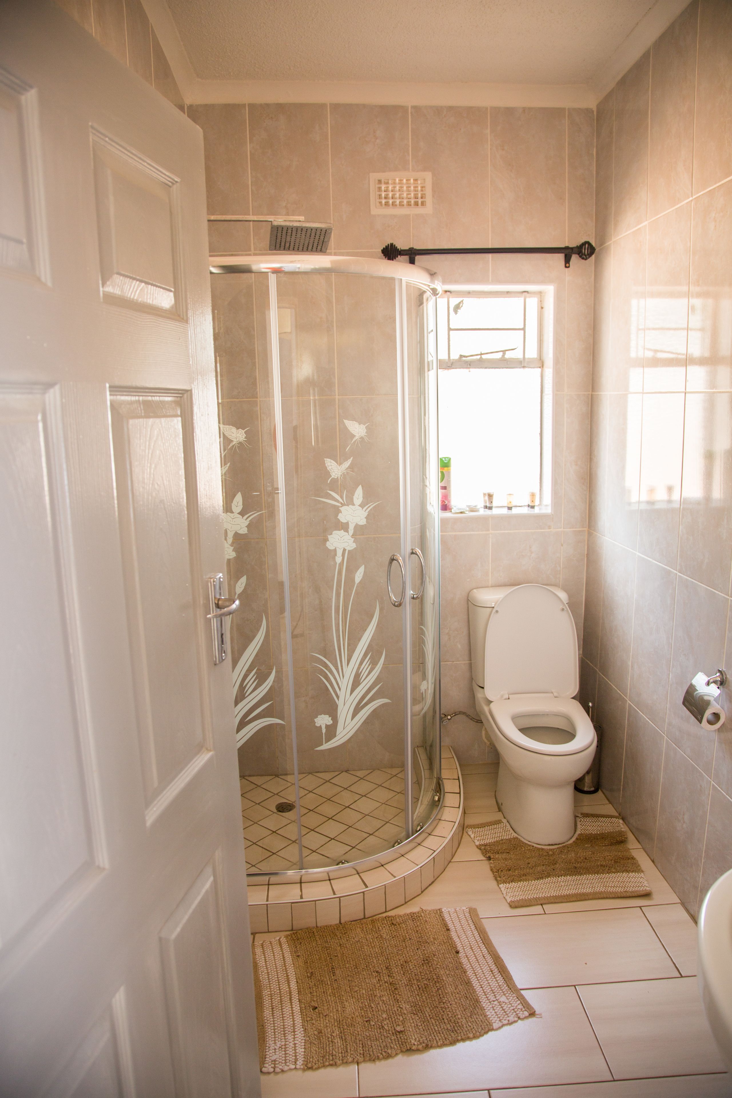 Un baño con ducha acristalada, inodoro y lavamanos.
