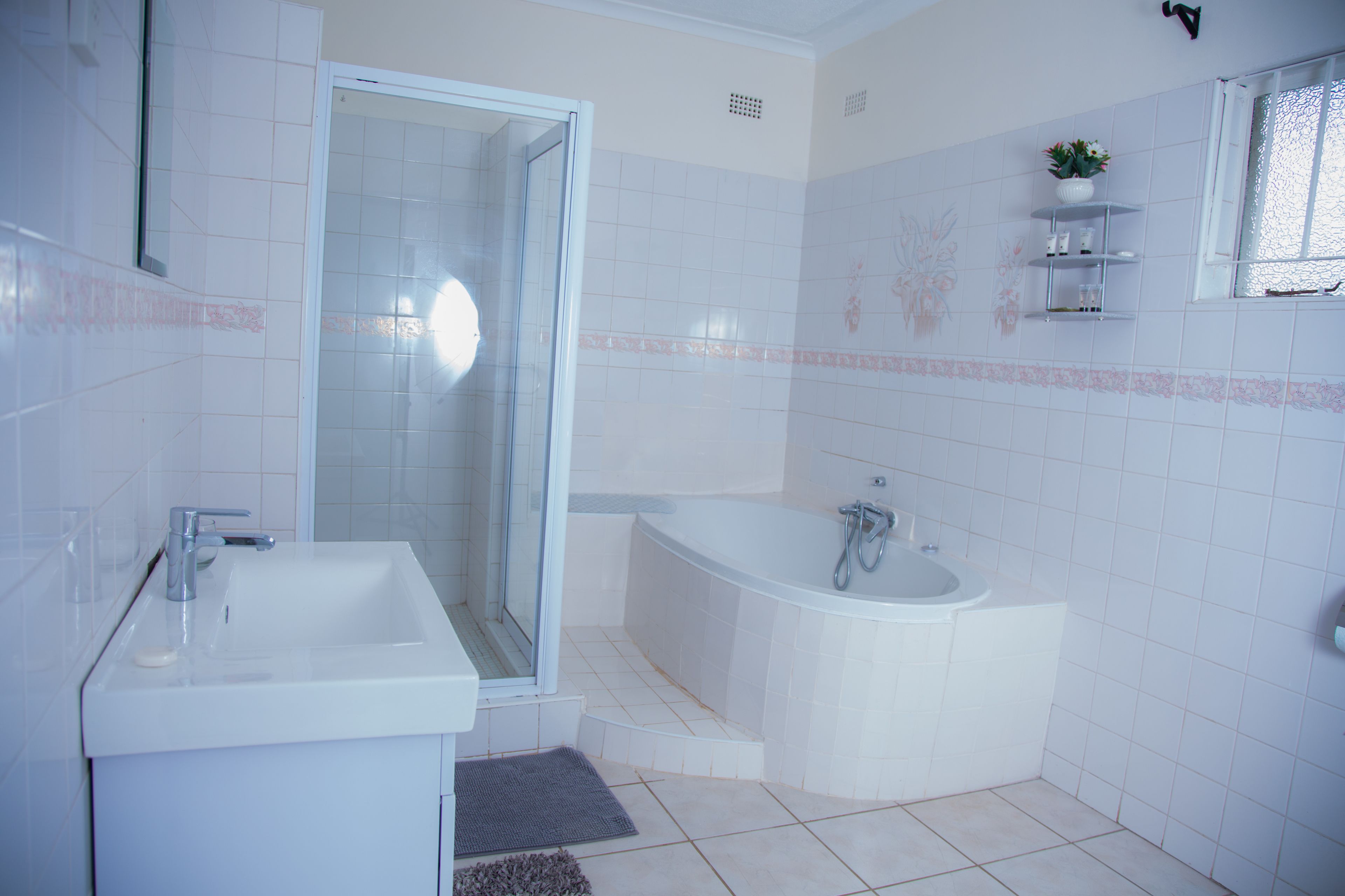 Une salle de bain moderne avec une douche à parois de verre, une baignoire sur pieds et un lavabo blanc.
