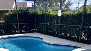 Une piscine avec un bord carrelé et un espace dédié à un jacuzzi.
