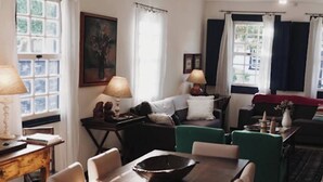 Et spiseområde med et træbord og stole, en sofa og en lampe.