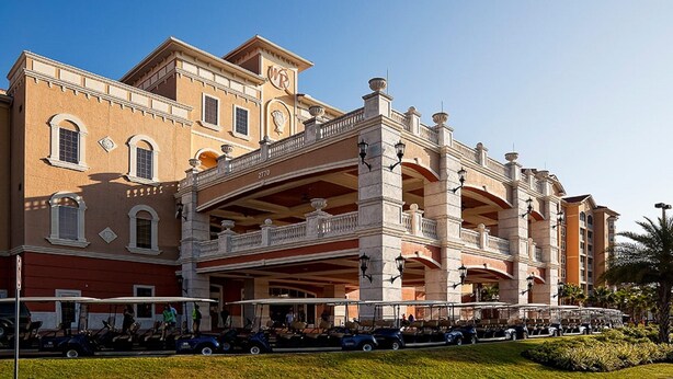 A large, historic building with multiple balconies and a covered walkway.
