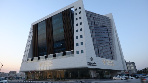 A modern hotel with a unique angular design, featuring large glass windows and a prominent entrance.