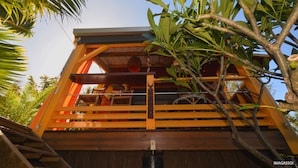 A wooden structure with a balcony, surrounded by lush greenery. - Poz Lagon (Saint-Paul)