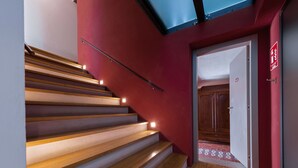 Eine Treppe mit Holzhufen und einer roten Wand.