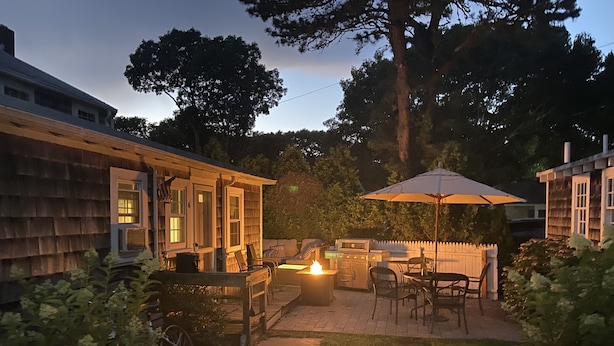 Un giardino sul retro con un barbecue, mobili da esterno e un braciere.