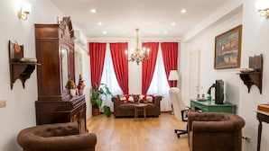 A living room with a sofa, two armchairs, a wooden cabinet, a chandelier, and a painting on the wall. - Casa Bastianello large apartment, view of Canal Vena Historic Center comfort (Chioggia)