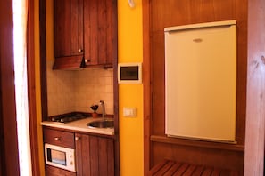 A compact kitchen with wooden cabinets, a built-in microwave, a sink, and a white refrigerator. - STUDIO with SEA VIEW TERRACE - 2 pax (All Inclusive) (Custonaci)