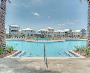 A swimming pool with lounge chairs and a stone wall.