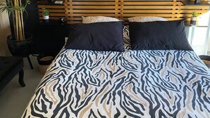 A bed with a zebra print bedspread, a wooden slatted headboard, and two woven wall hangings. - Villa overlooking the hill between Hyeres and St Tropez (Solliès-Pont)