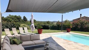 A covered outdoor seating area with a pool, lounge chairs, and a sofa. - Villa overlooking the hill between Hyeres and St Tropez (Solliès-Pont)