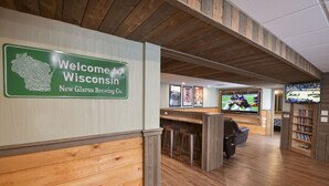 Ein Holzinterieur mit einem Schild, das „Willkommen bei der Wisconsin New Glarus Brauerei“ verkündet.