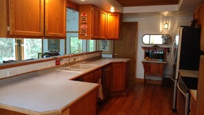 A kitchen with wooden cabinets, a sink, and a refrigerator. - "Enchantment"  Medford, Oregon (Medford)
