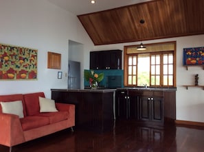 Relax in this stylish living area with a sofa, kitchenette, and vibrant artwork.