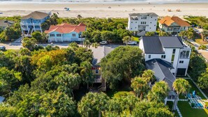 A coastal residential area with houses, a beach, and a clear sky.