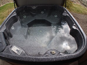 Ett bubbelbad med en kontrollpanel, flera justerbara munstycken och ett glaslock.