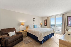 Une chambre à coucher comprenant un lit, un canapé, un bureau, une table de chevet et un balcon avec vue.