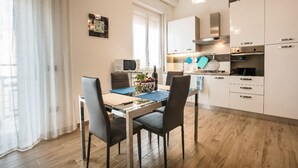 Une cuisine moderne avec des meubles blancs, un four à micro-ondes et une décoration en forme de cœur bleue accrochée au mur.