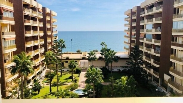 Un hôtel doté de nombreux balcons, d’une piscine et offrant une vue sur la mer.