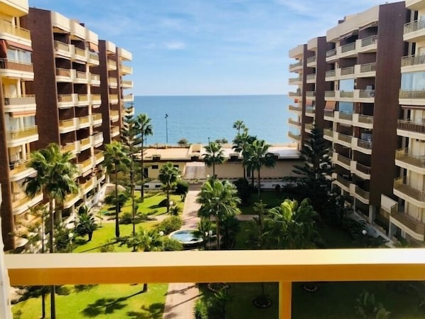 Un hôtel doté de nombreux balcons, d’une piscine et offrant une vue sur la mer.