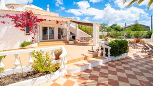 A house with a patio, outdoor seating, and a garden. - Casa Alegria · This villa is perfect for a family (Lagoa)