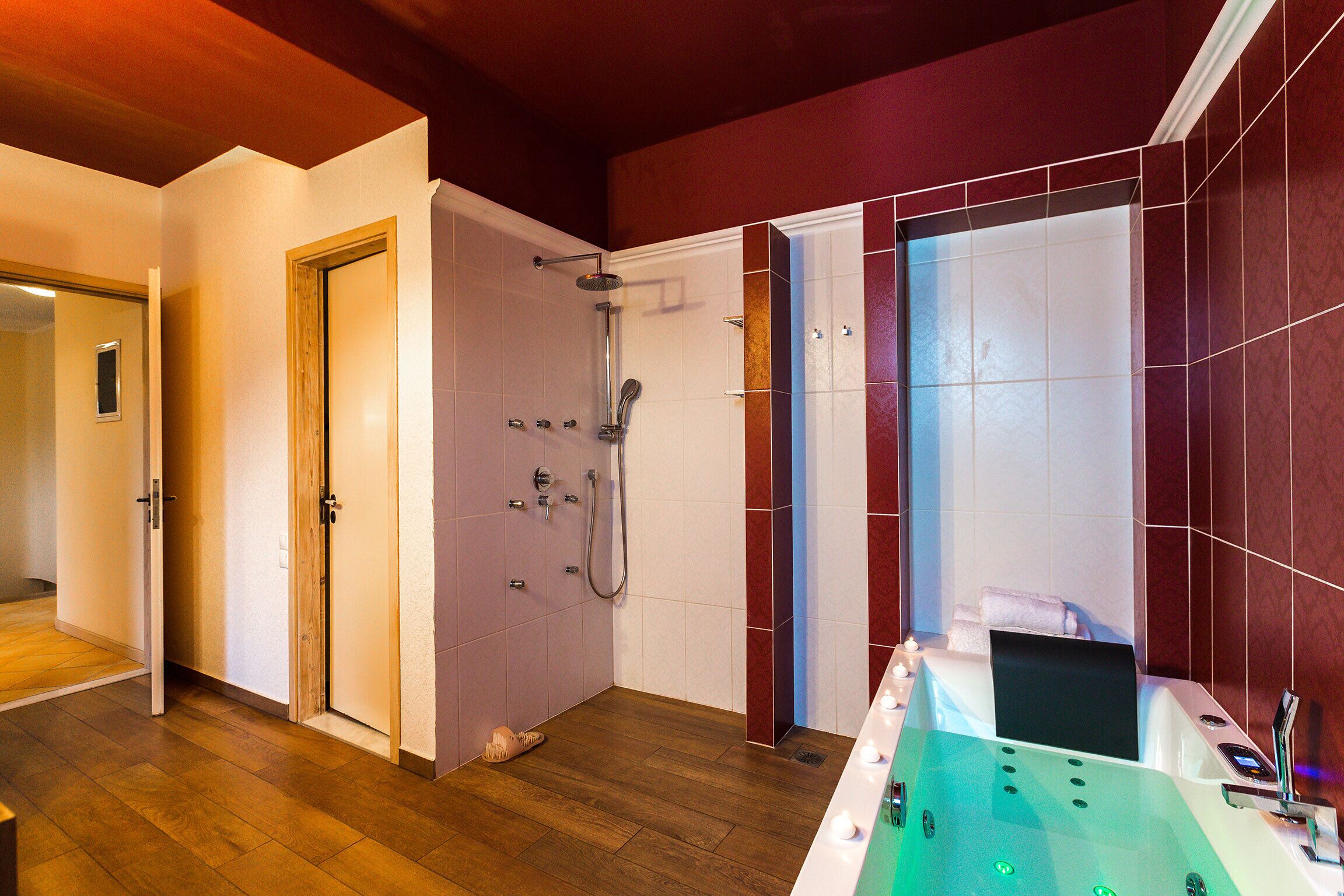 Un baño moderno con ducha, bañera y suelo de madera.