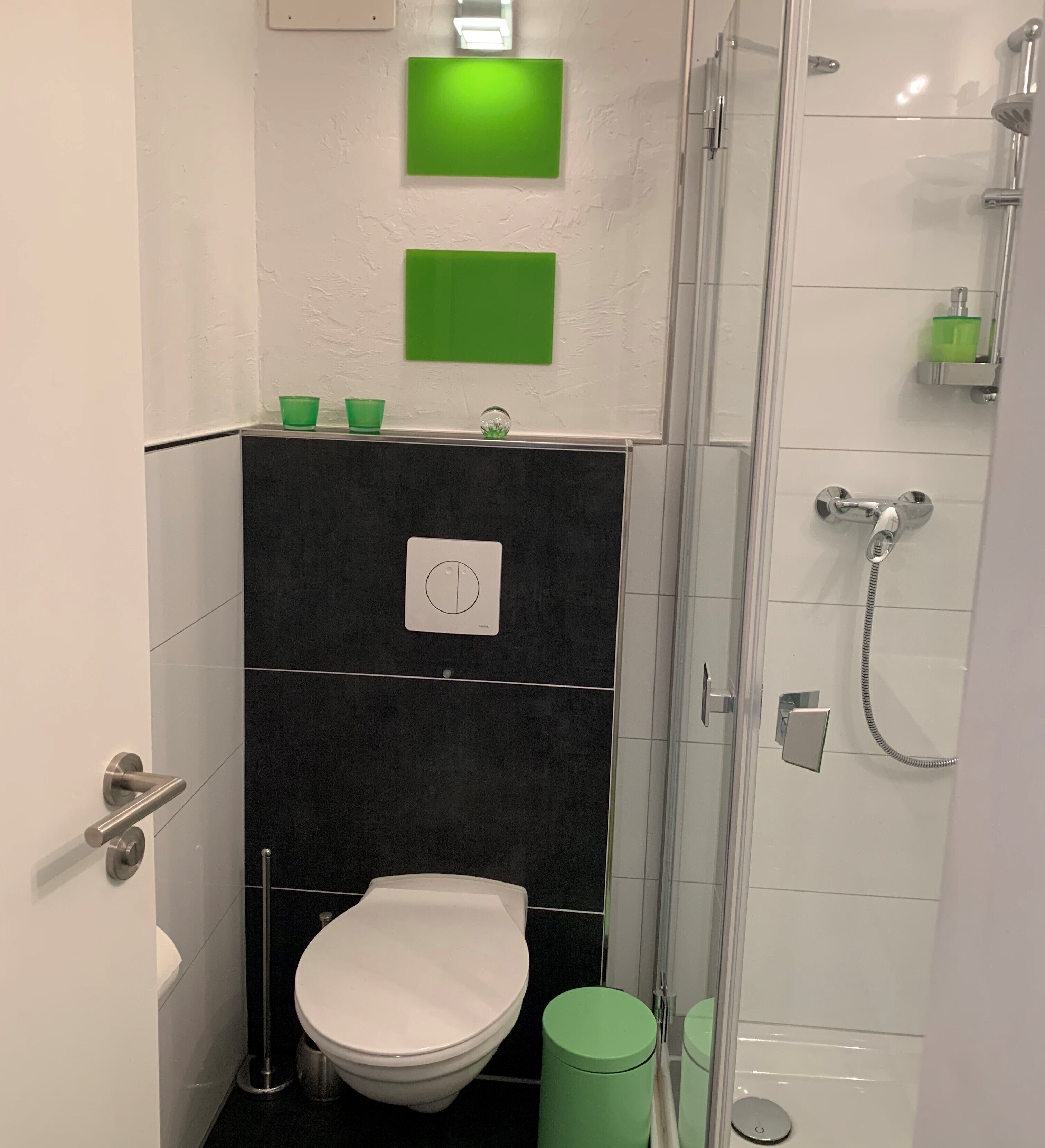 A bathroom with a toilet, a shower, and a sink.