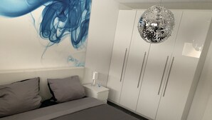 A bedroom with a bed, a nightstand, a wardrobe, and a decorative ceiling light. - Central apartment in Willingen (Willingen (Upland))