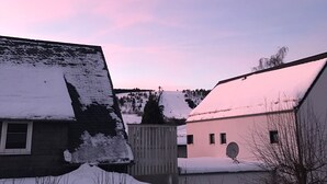 A residential area with houses covered in snow, a wooden fence, and a clear sky. - Central apartment in Willingen (Willingen (Upland))