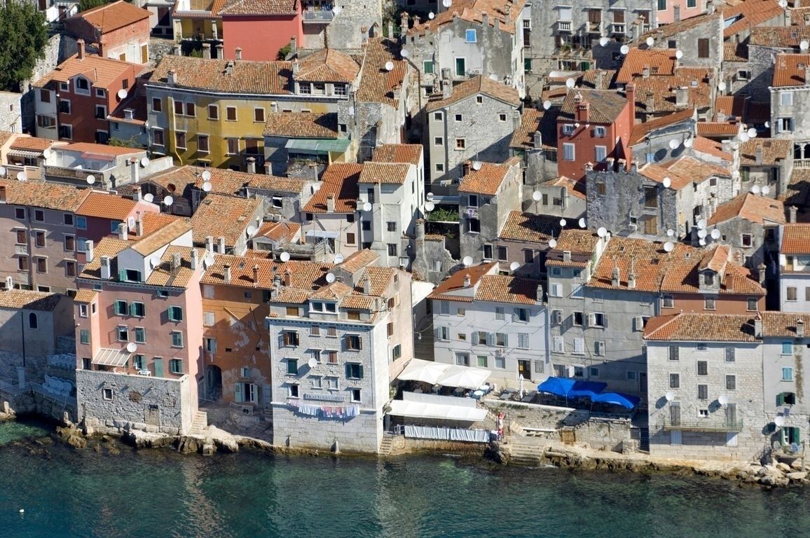 A densely packed coastal town with historic buildings, narrow streets, and a waterfront.