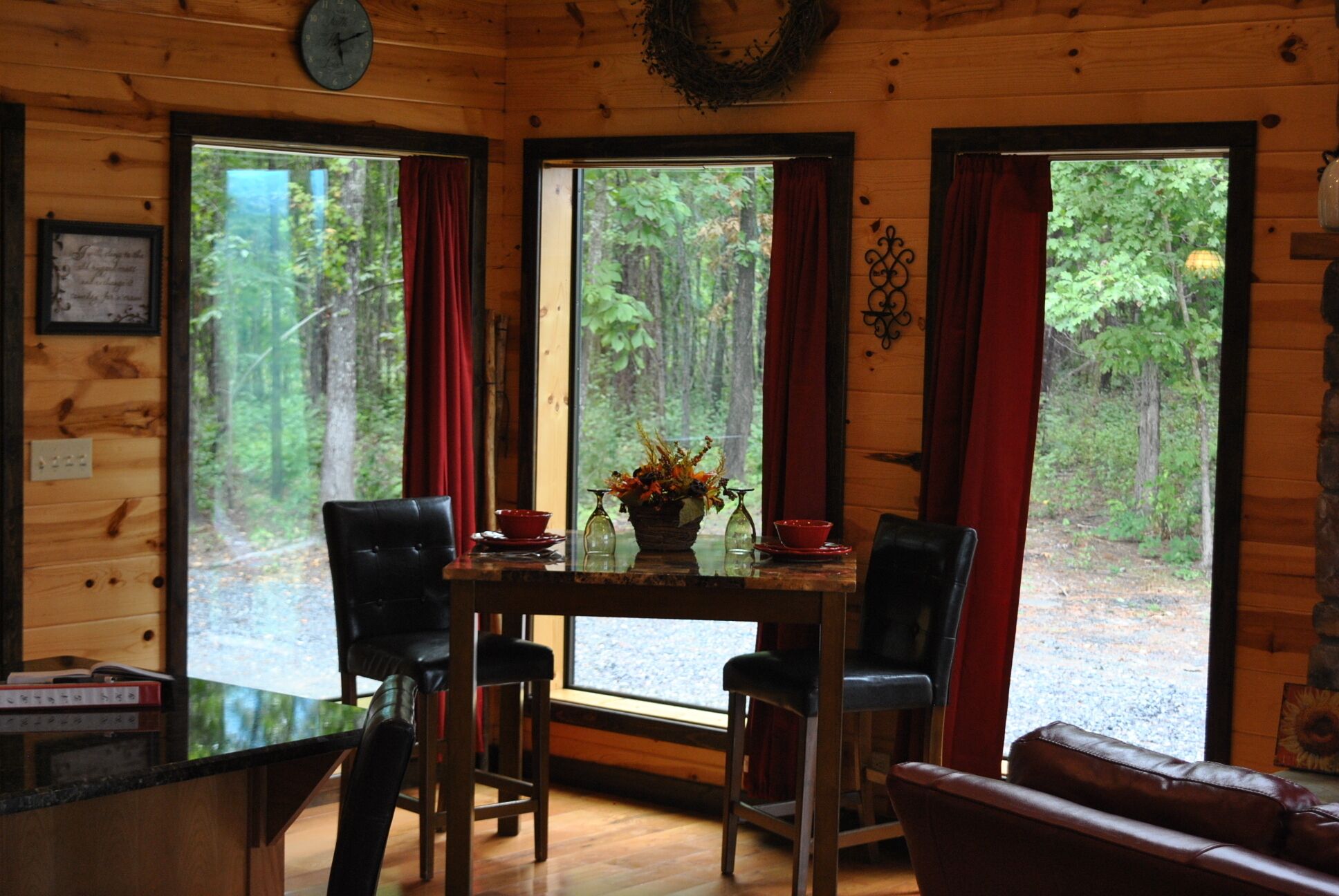 L'intérieur d'un chalet en bois, avec une table à manger, des chaises et un canapé.