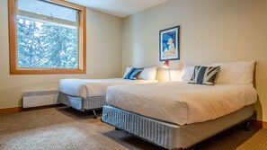 Two single beds with matching headboards and footboards, adorned with white bedding and pillows, offer a cozy retreat.