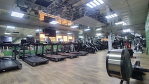 Una palestra con tapis roulant, cyclette e macchinari per pesi.