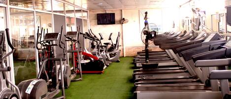 A gym with treadmills, stationary bikes, and elliptical machines.