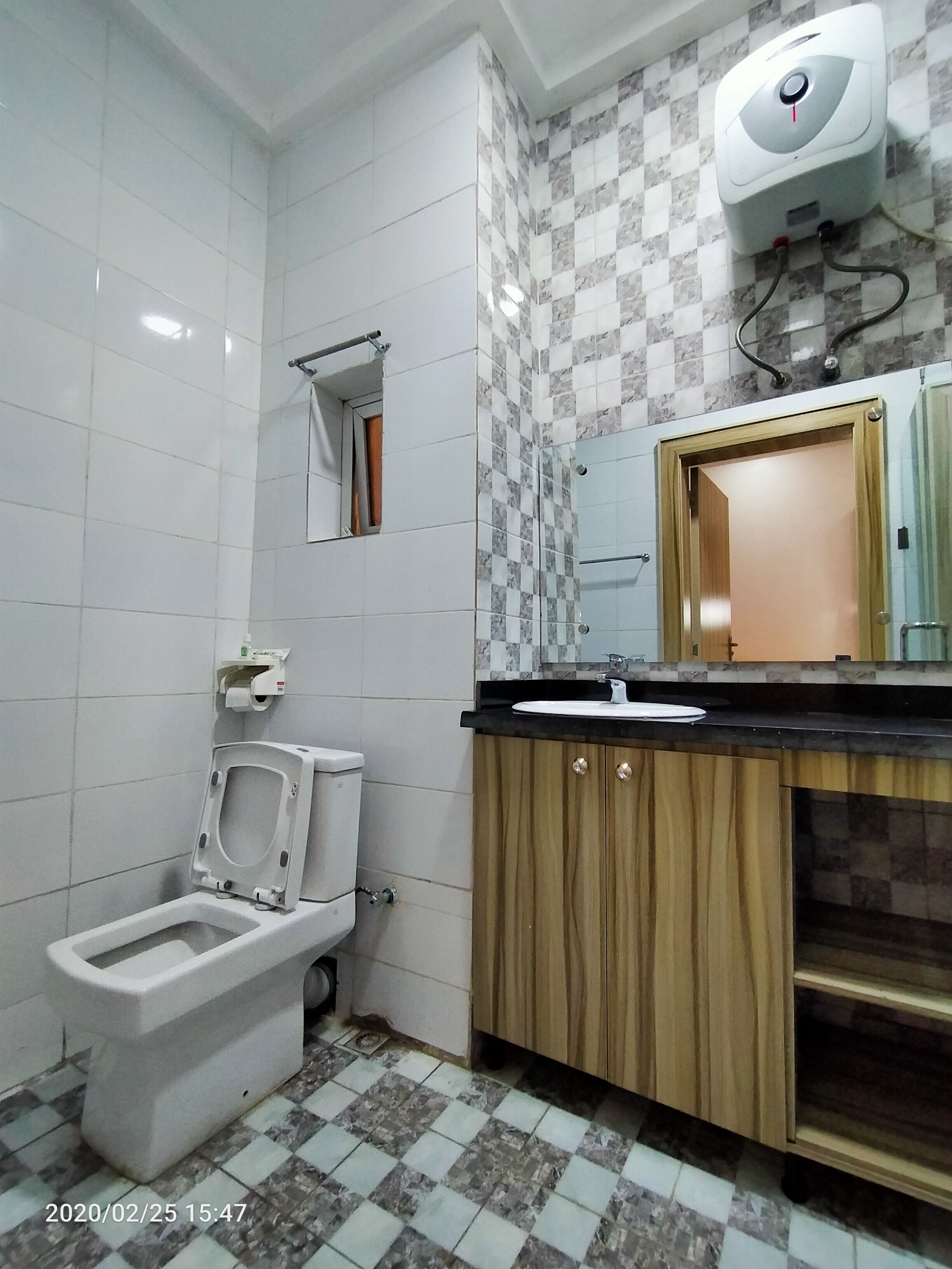 A bathroom with a toilet, sink, and mirror.