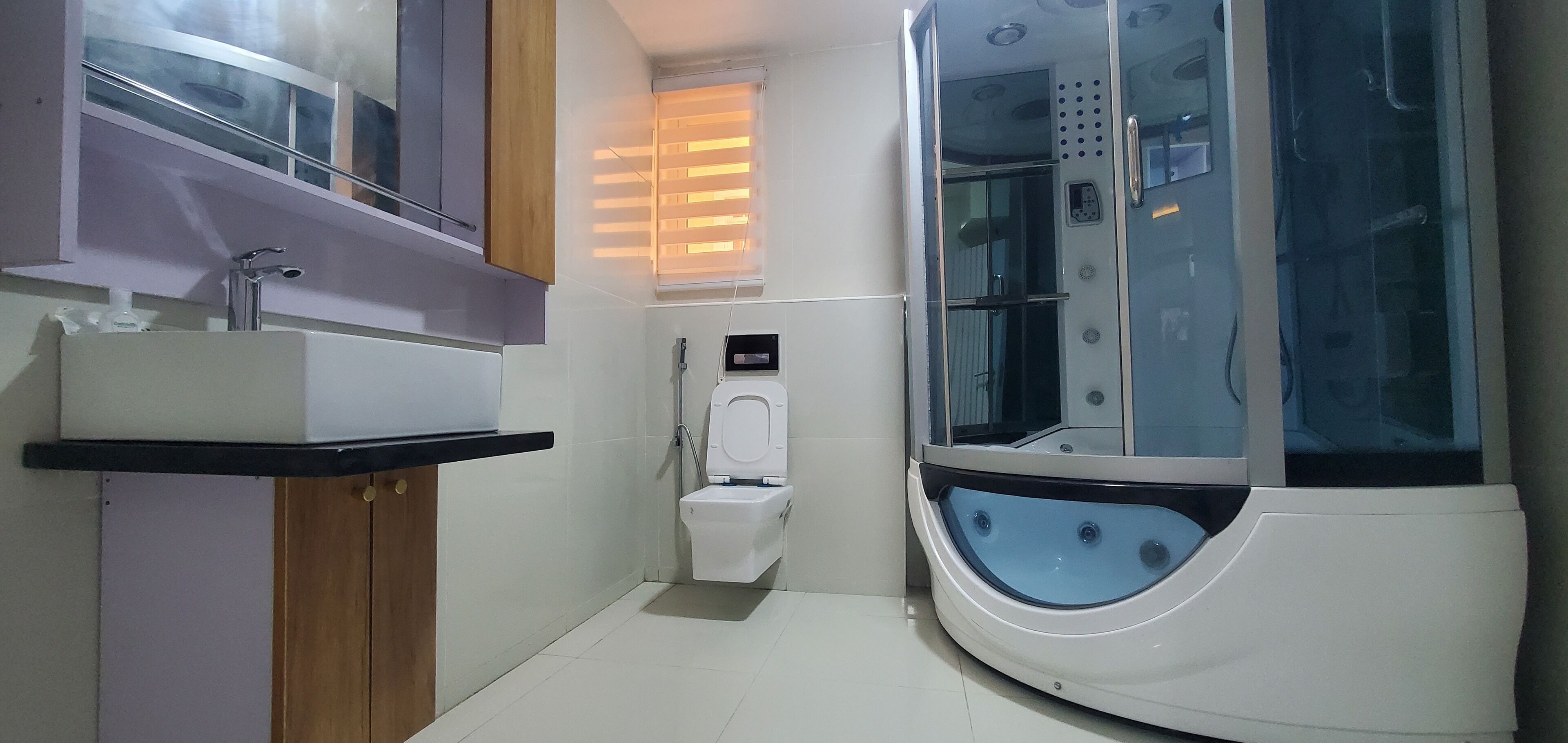 Ein modernes Badezimmer mit Toilette, Waschbecken und einer Dampfdusche.
