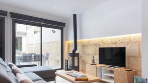 Ein modernes Wohnzimmer mit einer Couch, einem Couchtisch, einem Fernseher und einem Kamin.