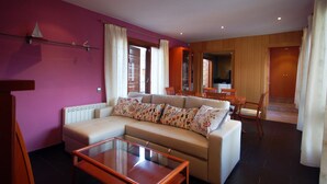 A living room with a beige sectional sofa, a glass coffee table, and a wooden dining table with chairs. - CENTRIC APARTMENT with POOL in TOSSA (Tossa de Mar)