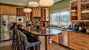 Una cocina moderna con armarios de madera, una isla central e iluminación colgante.