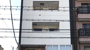 Ein zweistöckiges Gebäude mit einer steinernen Fassade und einem großen Fenster.