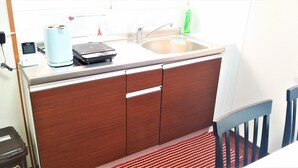 A kitchen with a sink, a coffee maker, and a small appliance on the counter. - Panda Stay Okayama (Okayama)