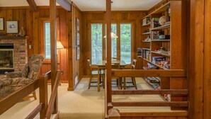 Ein gemütliches Blockhaus-Interieur mit Kamin, Holzmöbeln und einer Bücherwand.