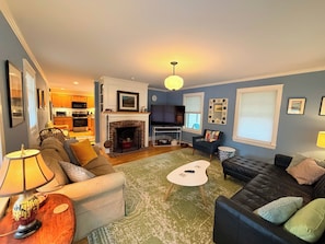 A living room with a fireplace, a sofa, a coffee table, and a television.