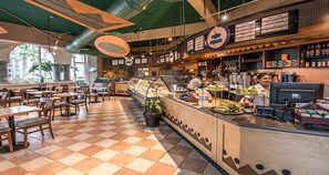 A cafe with a checkered floor, a counter with a display case, and a menu board.