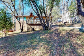 Escape to a secluded cabin surrounded by mature trees and a rustic front porch.