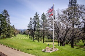 Enjoy a round of golf surrounded by lush trees and a majestic mountain range.