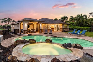 A two-story house with a swimming pool and hot tub, surrounded by palm trees and a well-maintained lawn. - Kahakai Estates Hale: Posh Gold Coast Home w/ Pool, Spa, AC & Sunset Views (Kailua Kona)