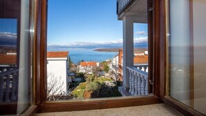 A balcony with a view of the sea and buildings. - Apartment in Njivice with Seaview, Balcony, Air condition, WIFI (4687-1) (Njivice)